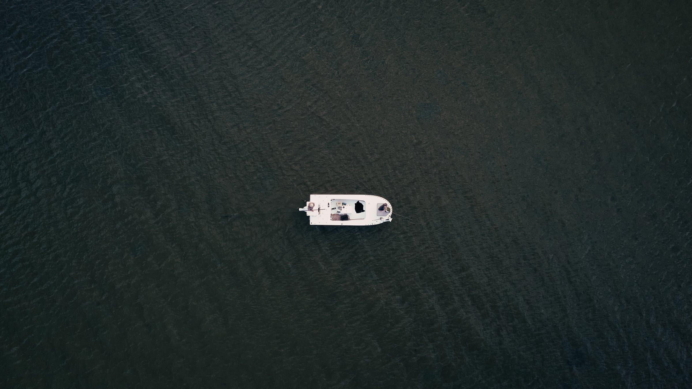Aerial view of a skiff on dark Louisiana marsh water during a redfish fly fishing trip.
