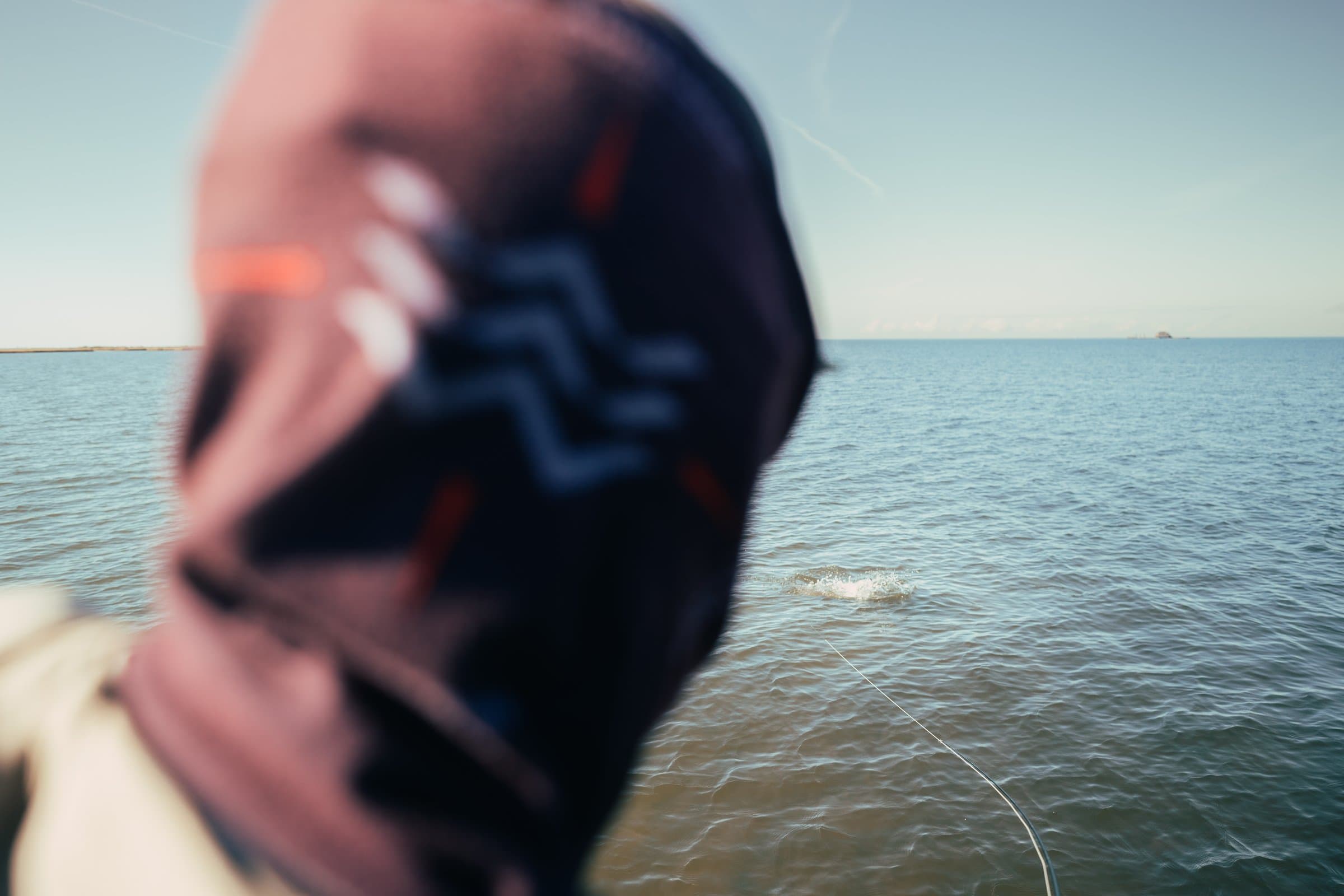 Angler sight fishing for redfish on shallow Louisiana flats.